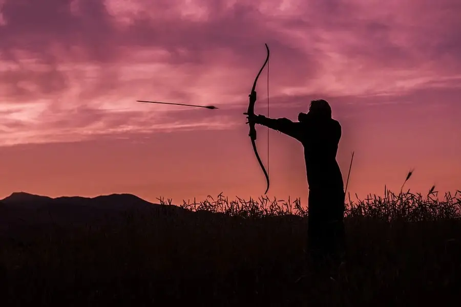 Shooting a bow at sunset