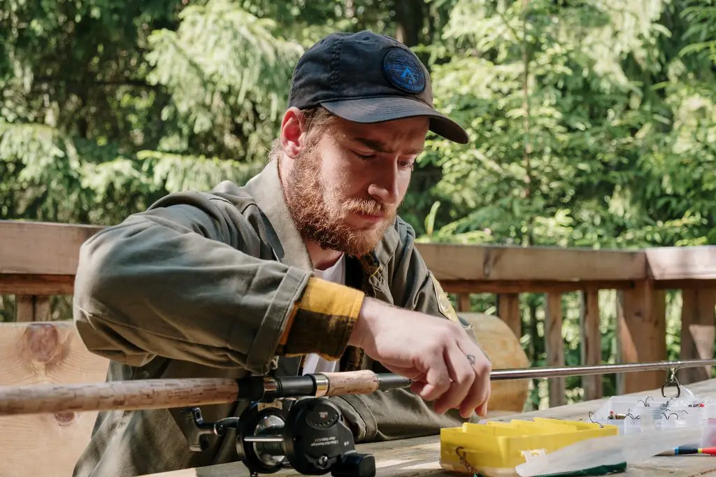 A man choosing an equipment to calibrate his fishing reel