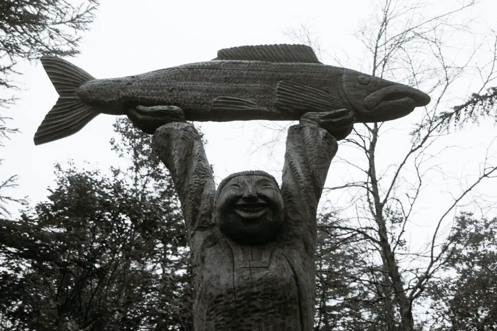Statue holding a huge bass fish
