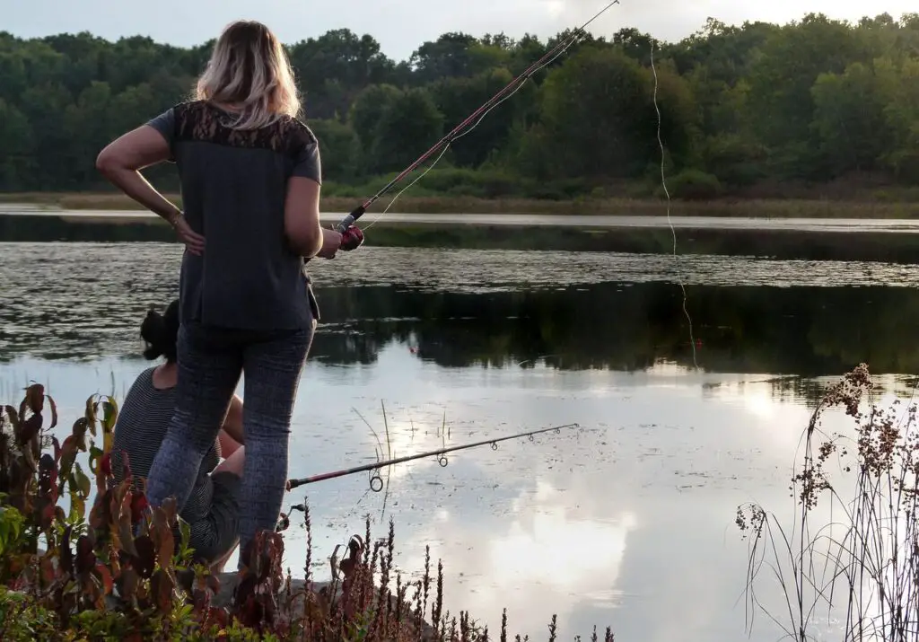 Two girls fishing on a creek using ultra-light rods