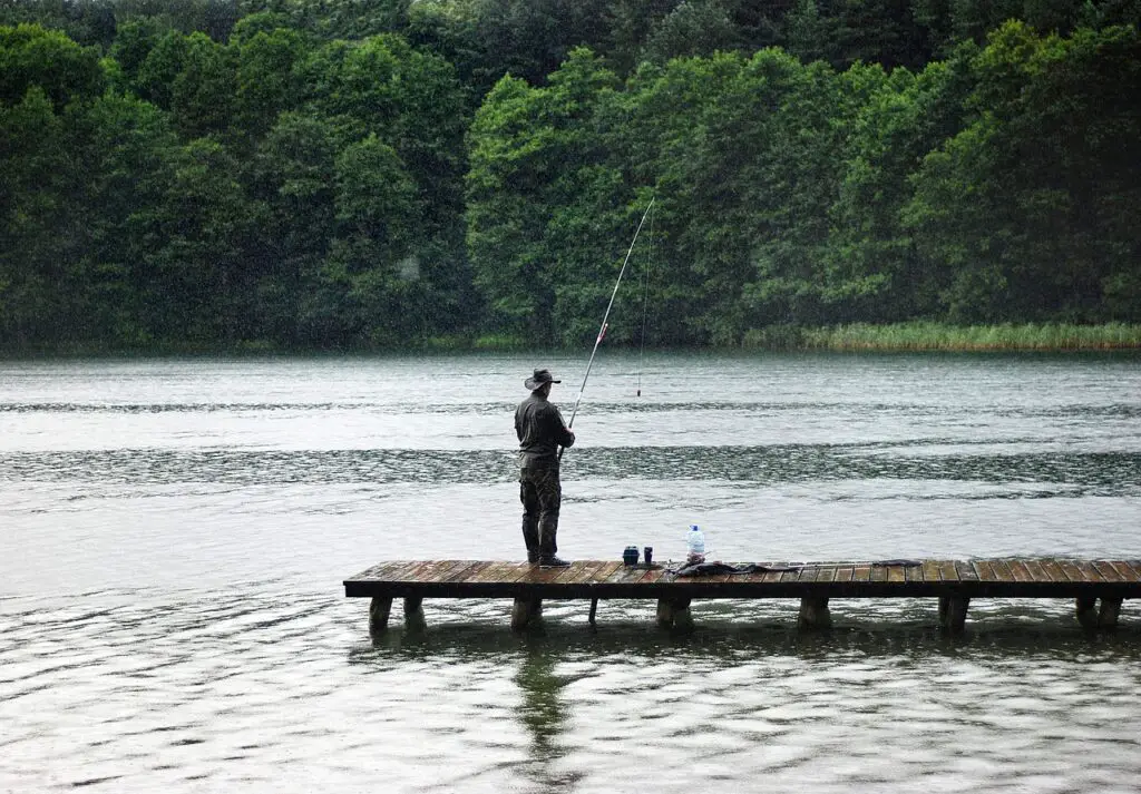 A man fishing in the lake on a rainy season