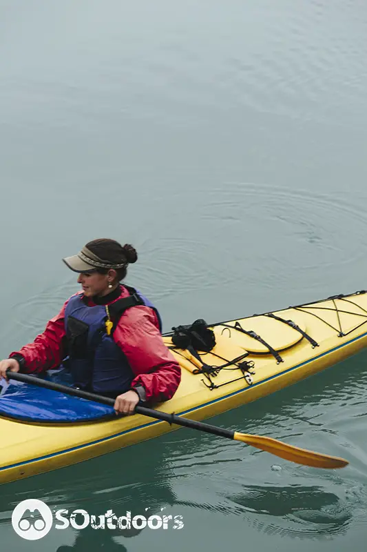 Female sea kayaker paddling pristine waters of Muir inlet
