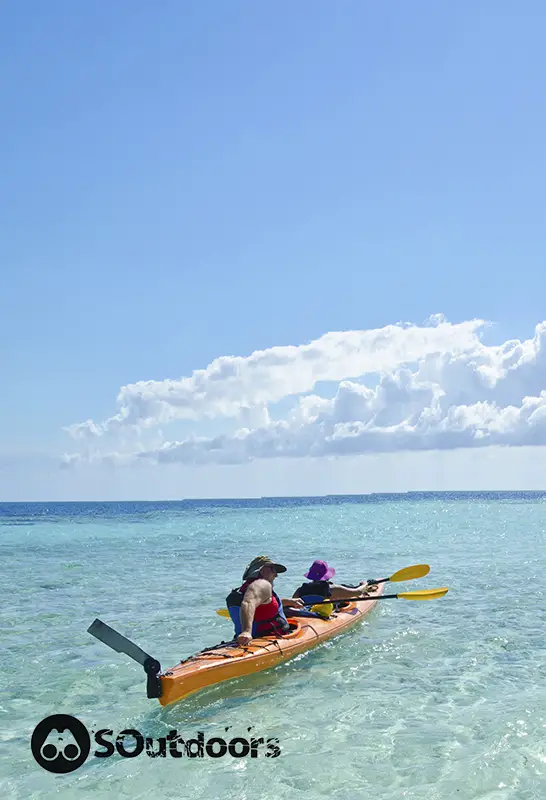 Man and woman embark in a sea kayak near the barrier reef somewhere in the Caribbean sea