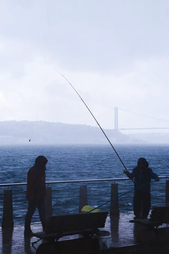 Two men fishing on a rainy day 