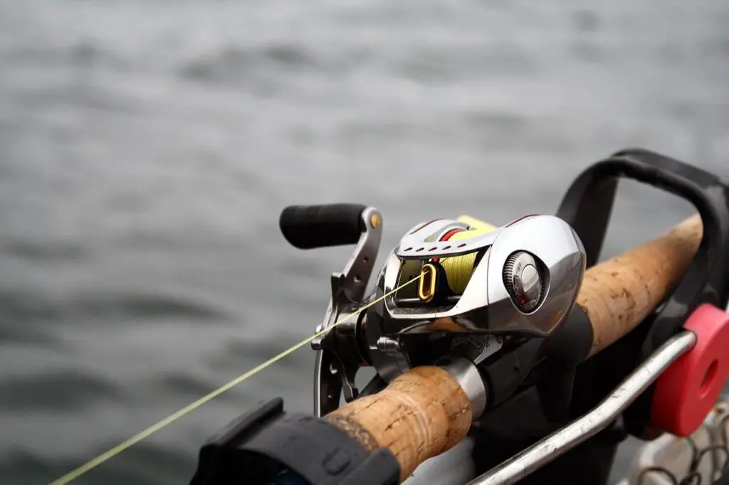 Metal chrome colored baitcast reel mounted on fishing rod