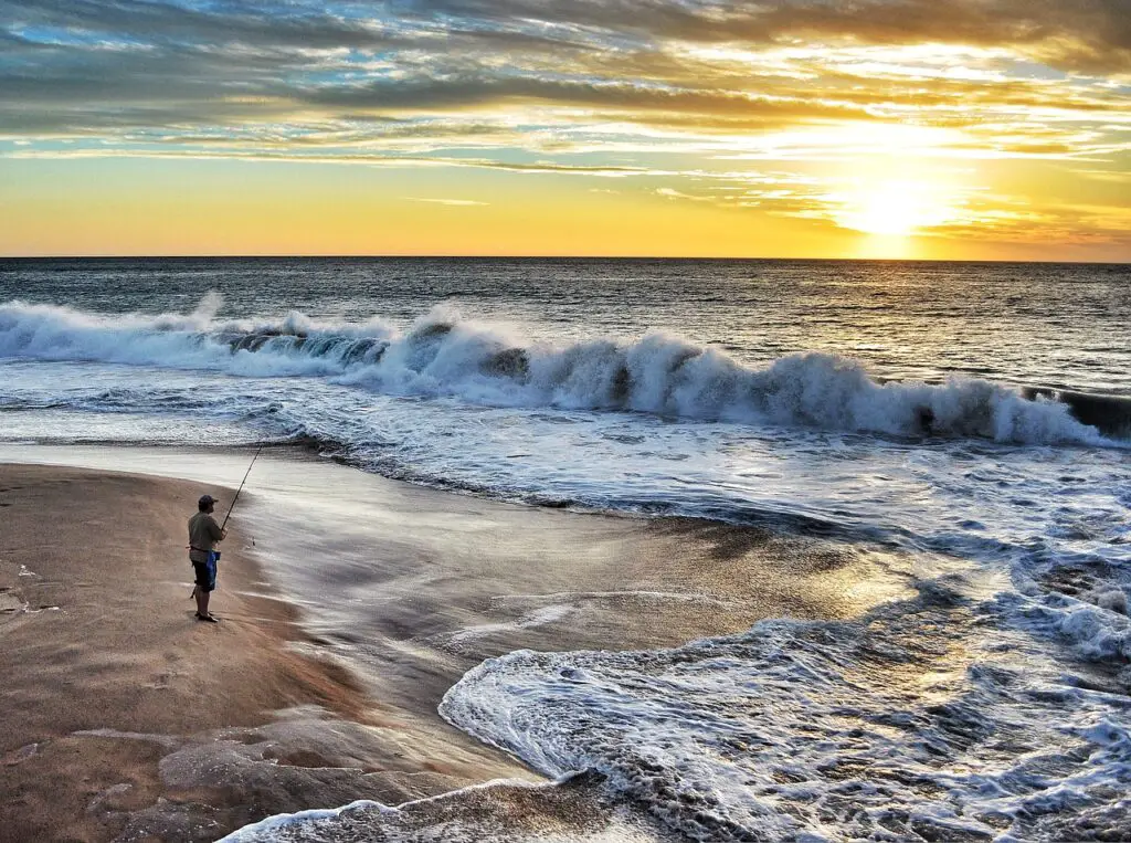 Man fishing in the sea with big waves