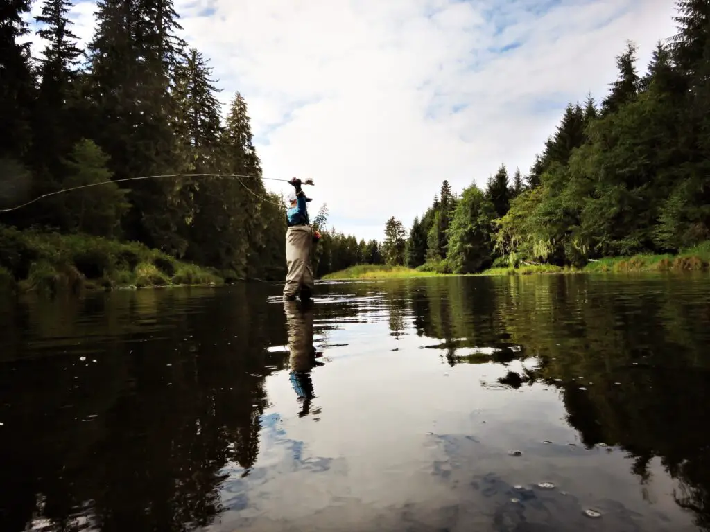 A fisherman casting his fly fishing rod