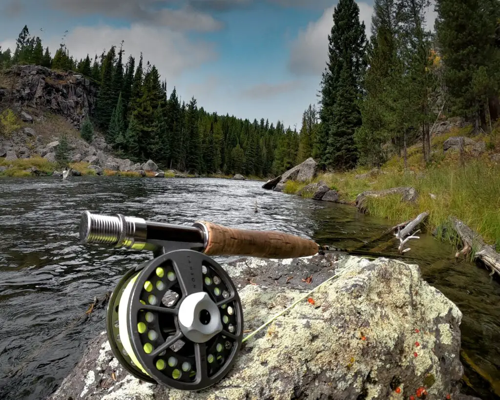 Fly fishing rod on the rock near the lake