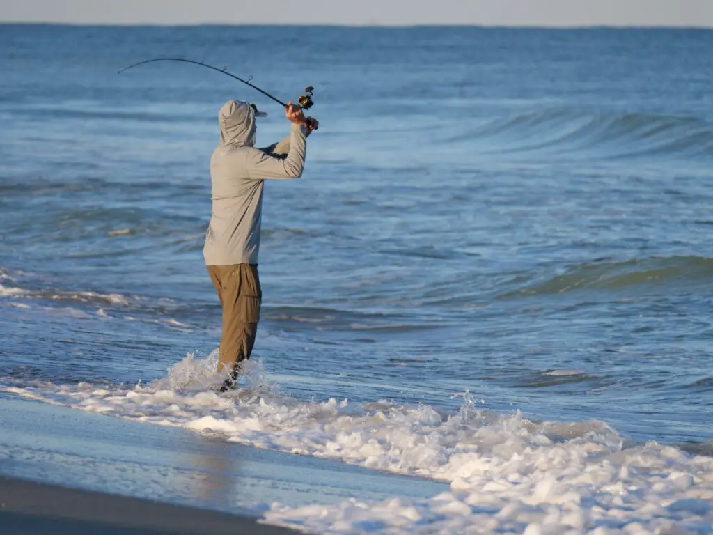 A fisherman casting his fishing rod by the seashore