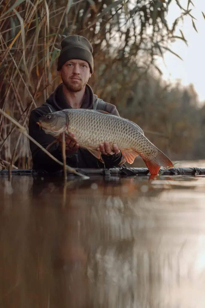 A fisherman holding a carp